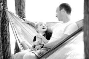 Father and son sitting on hammock