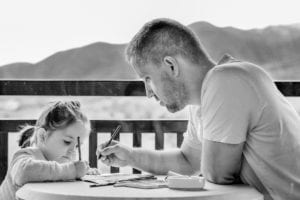 Father doing school work with young daughter