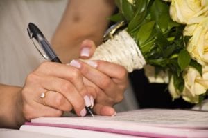 Bride holding bouquet and signing pre nup