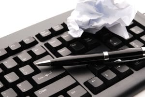 Pen and crumpled paper on keyboard