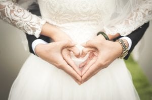 Newlyweds making heart sign with hands