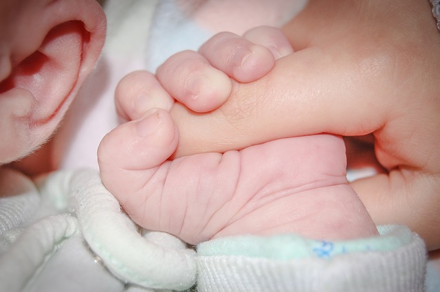 Baby grasping adult finger