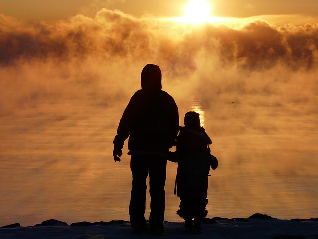 Parent and child watching sunrise