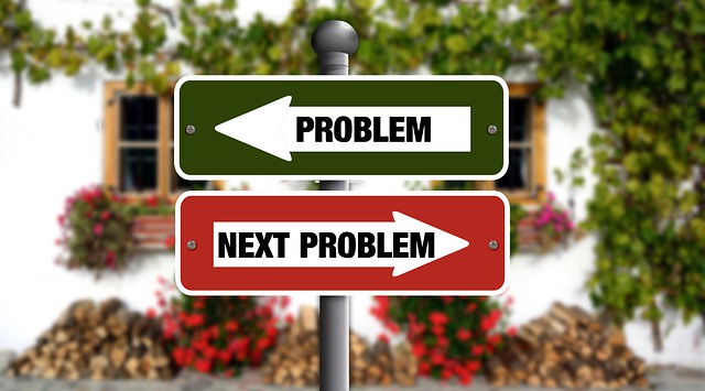 Two signs, one says "problem" the other says "next problem"